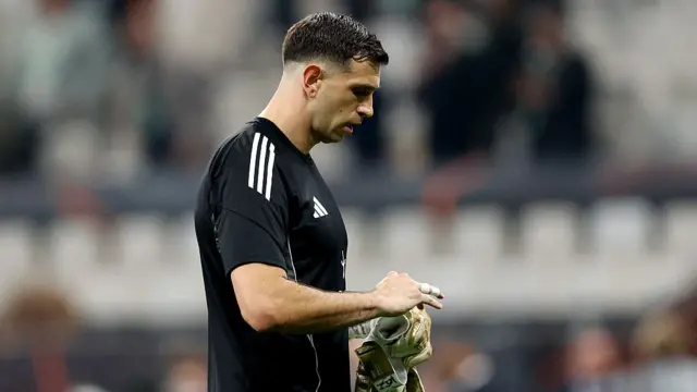 Emiliano Martinez of Aston Villa adjusts the tape on his hand during the warm u
