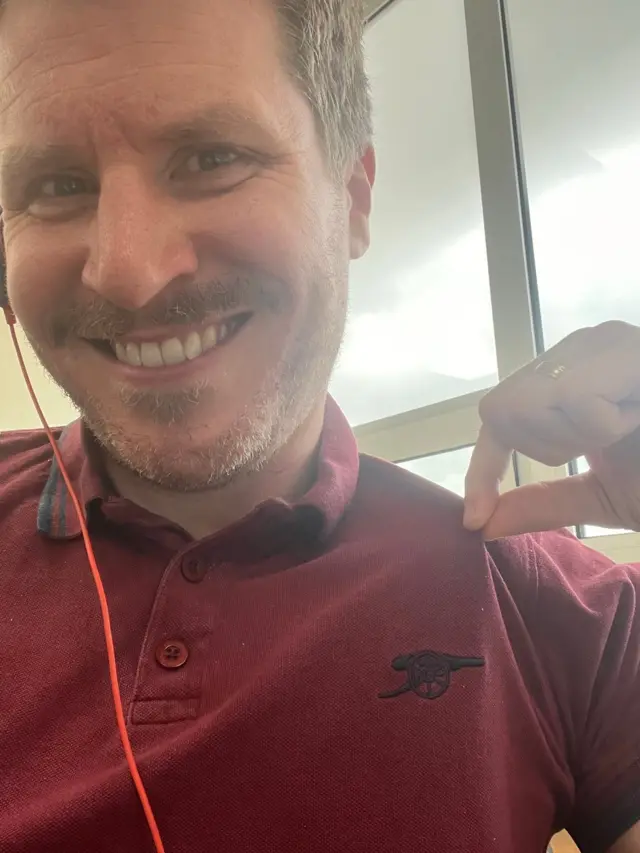 Andrew wearing an Arsenal polo shirt