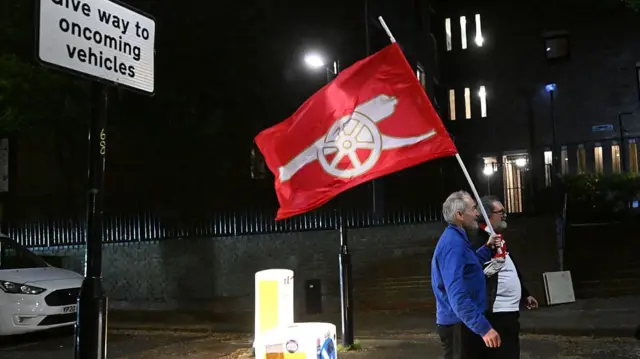 fan holding an Arsenal banner
