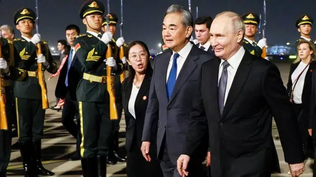 Putin (right) was received by Chinese foreign minister Wang Yi