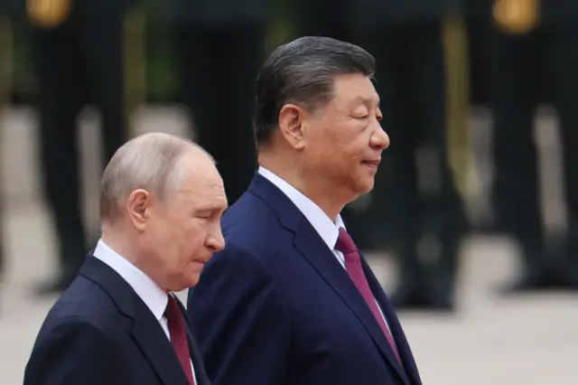 Russian President Vladimir Putin (L) walks with Chinese President Xi Jinping (R)