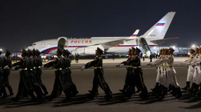 Chinese honour guards march in formation near the aircraft