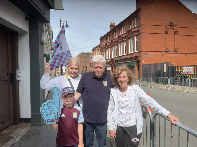 Marie, Ethan, George and Silvie waiting in the street for the parade