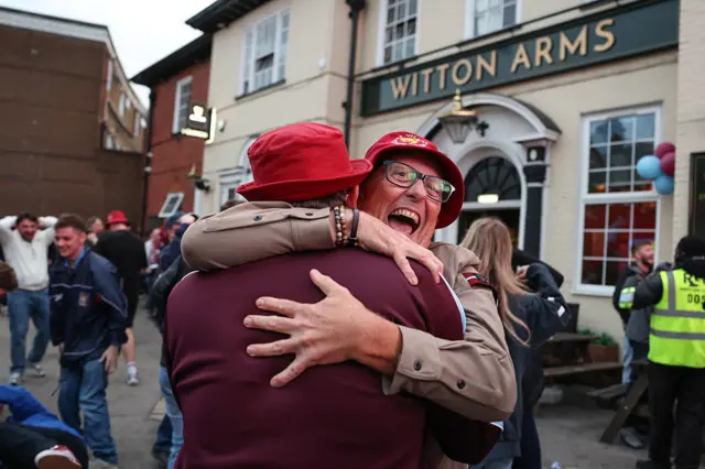 Supporters of Aston Villa cheer after their team's second goal before the half, as they watch the UEFA Europa League final football match between SC Freiburg and Aston Villa on television at the Witton Arms pub near Villa Park in Birmingham, central England on May 20, 2026