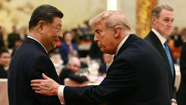 Trump pats Xi on the arm in a banquet hall