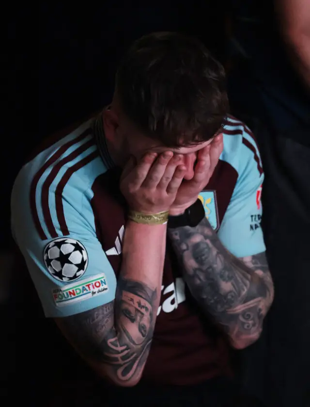 An Aston Villa fan holds his head in his hands