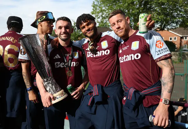 Players with the trophy on the bus