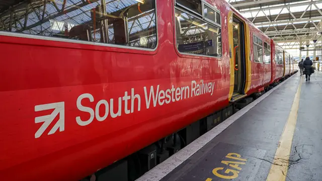 A red South Wester Railway train at the station platform