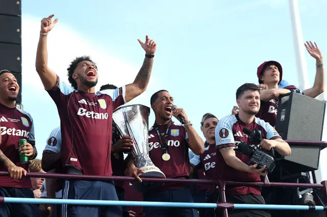 Matty Cash, Morgan Rogers and Tammy Abraham of Aston Villa celebrate on the team bus during the Aston Villa trophy parade
