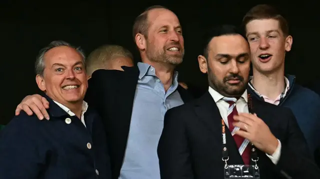 Prince William celebrates with two other men