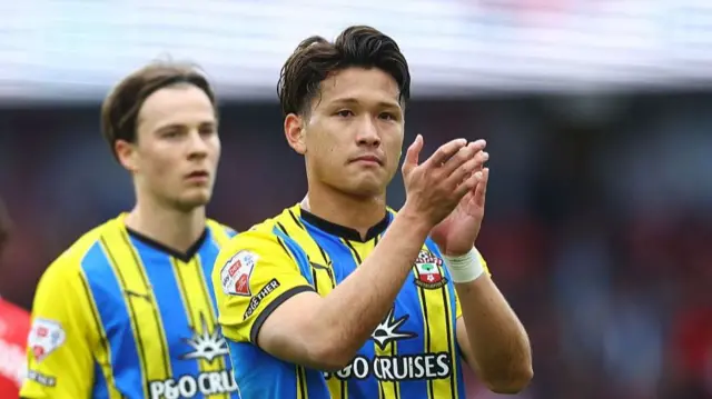 Kuryu Matsuki in the yellow and blue southampton kit applauding the fans