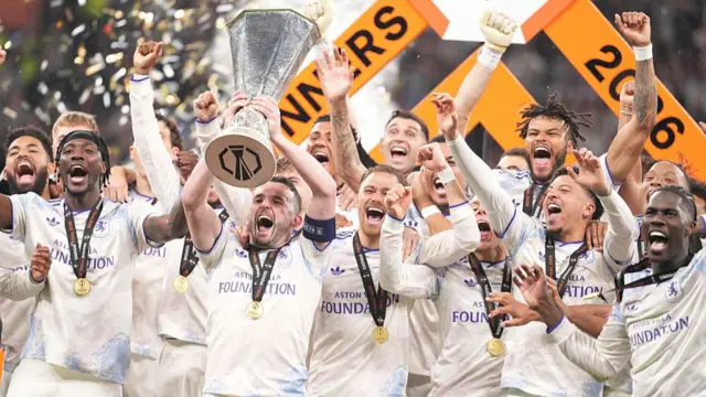 John McGinn lifts the trophy surrounded by his Aston Villa teammates