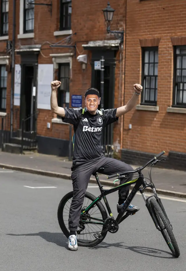 A boy on a bike with a mask on