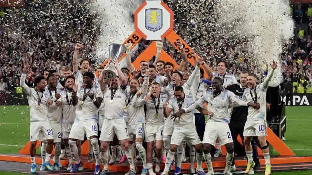Aston Villa's team lift the trophy with confetti in the air