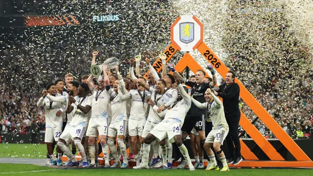 John McGinn lifts the Europa League trophy surrounded by Aston Villa teammates