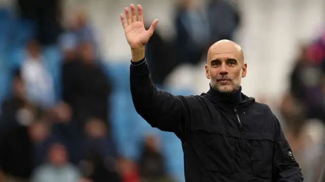 Manchester City's Spanish manager Pep Guardiola waves to fans on the pitch