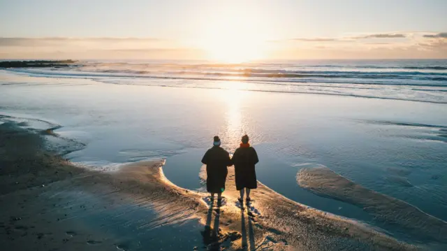 Swimmers at the beach in Cornwall at sunrise