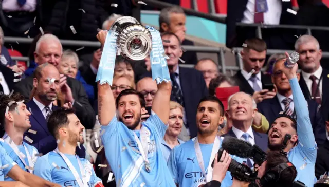 Manchester City players celebrate after being presented with the FA Cup trophy at Wembley Stadium