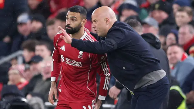 Arne Slot, Manager of Liverpool talks with Mohamed Salah