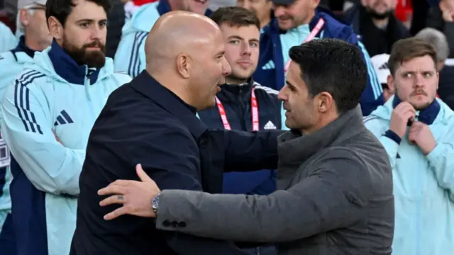 Arne Slot head coach of Liverpool embracing Mikel Arteta manager of Arsenal