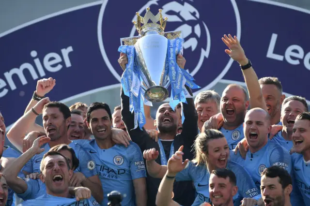 Manchester City manager Pep Guardiola holds the winner's trophy aloft