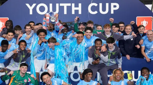 Manchester City players and staff celebrate with the trophy after they won the FA Youth Cup final