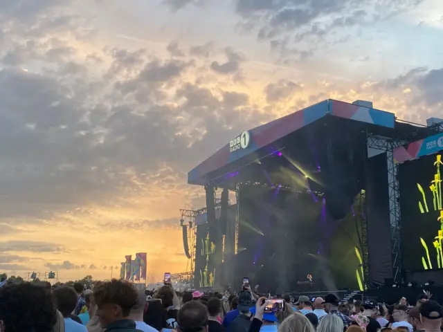 Sunset behind the Main Stage at Big Weekend where Fatboy Slim is performing in front of a big crowd