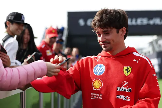 Charles Leclerc signs an autograph for a fan