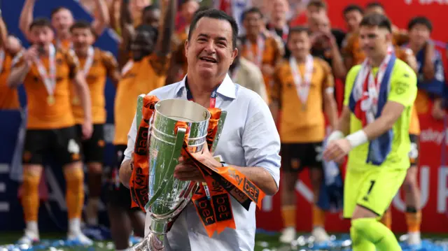 Acun Ilicali holds the play-off final trophy