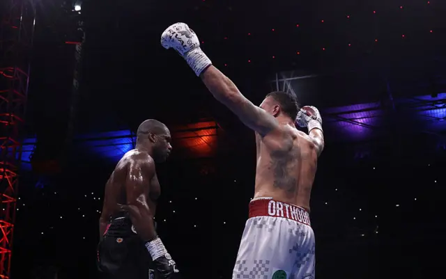 Oleksandr Usyk with his hands in the air next to Daniel Dubois