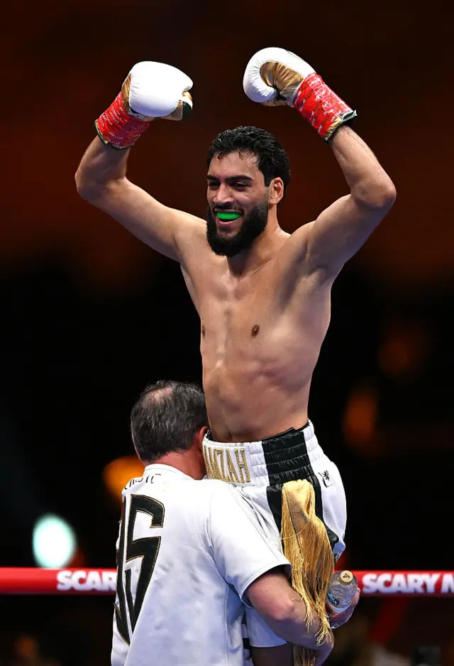 Hamzah Sheeraz is lifted up by Andy Lee
