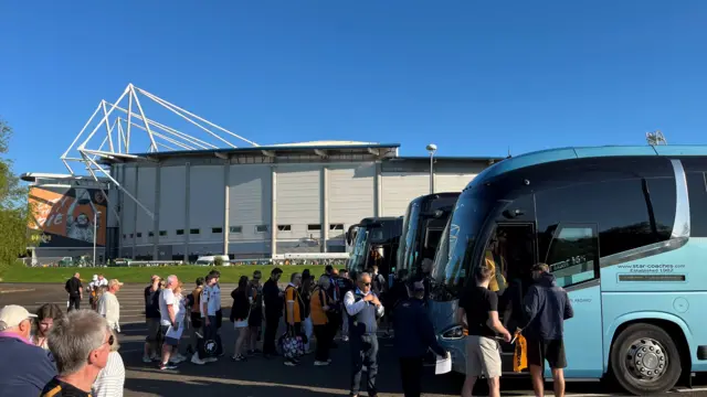 Fans board coaches outside the Hull City homeground