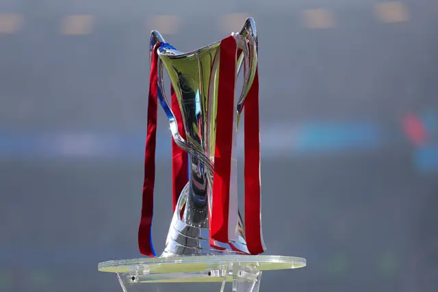Trophy on the plinth with both teams' ribbons