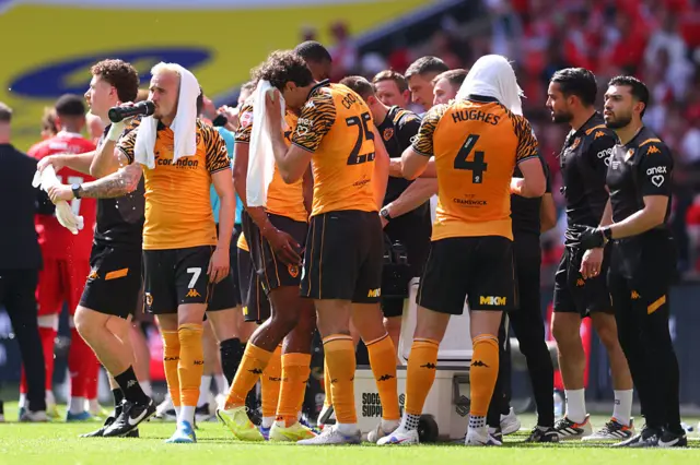 Players of Hull City cool themselves down with wet towels during a break for the hot weather conditions