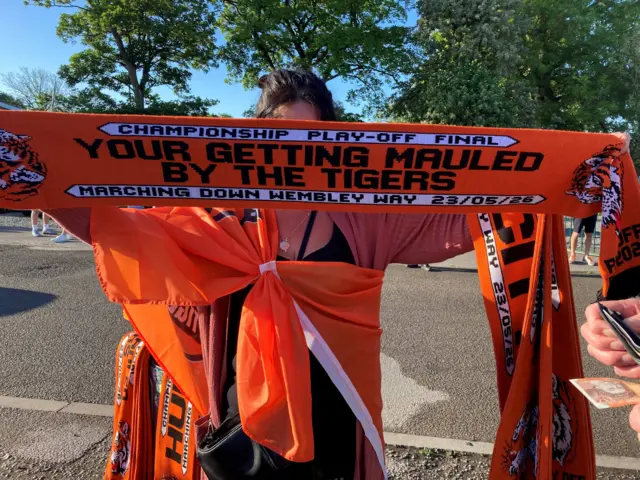 A woman holding a Hull City supporters scarf