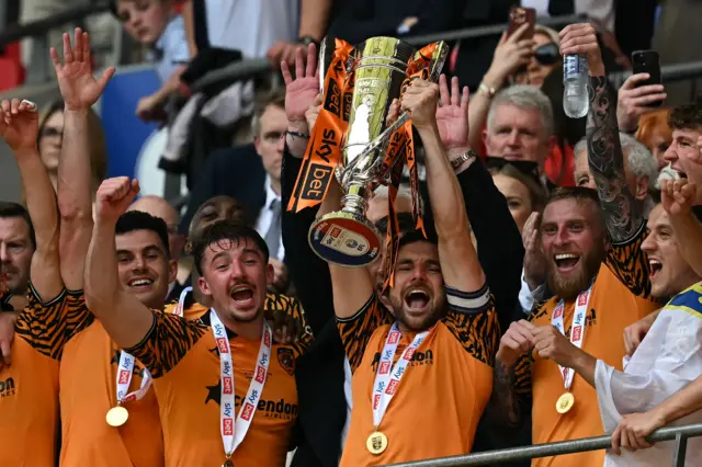 Hull City's Lewie Coyle holding up the Championship play-off final trophy.