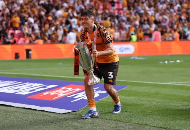 Ryan Giles holds the play-off final trophy