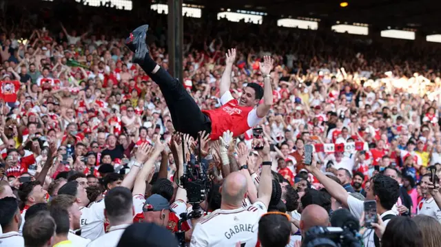 Mikel Arteta gets lifted by supporters