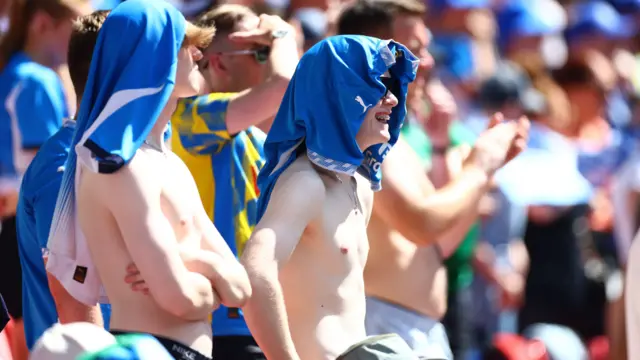 Stockport fans with shirts off and smiling