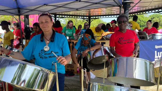 Steel band members play drums