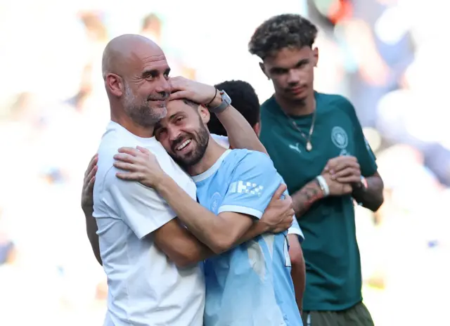 Guardiola and Bernardo hug on the pitch during their farewells