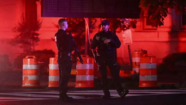 Secret Service officers and members of the National Guard stand near the White House after a gunman opened fire in Washington DC.