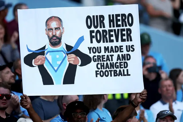 'Our hero forever' sign in the crowd with Pep as superman