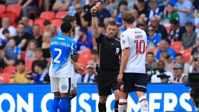 Josh Dacres-Cogley is shown a red card by the referee