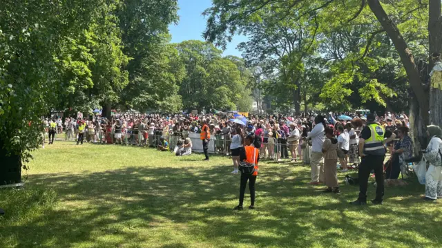 Crowd gathered at barriers in park