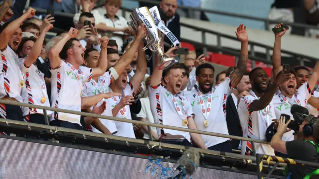 Bolton players lift the trophy