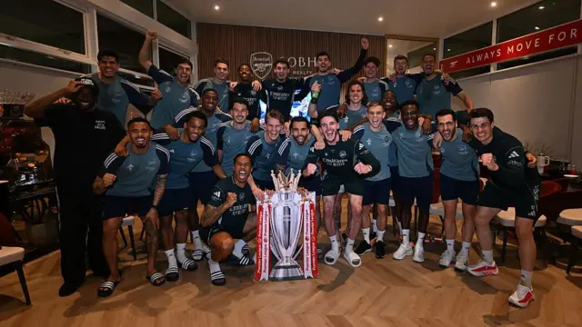 Arsenal players with a cut out of the Premier League trophy