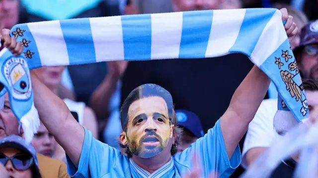 A fan of Manchester City wearing a face mask of Bernardo Silva