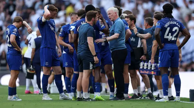 David Moyes, Manager of Everton, talks to a member of coaching staff during a break in play