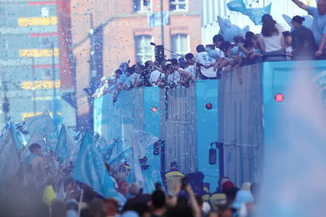 Players of Manchester City take part in an open-top bus parade in Manchester